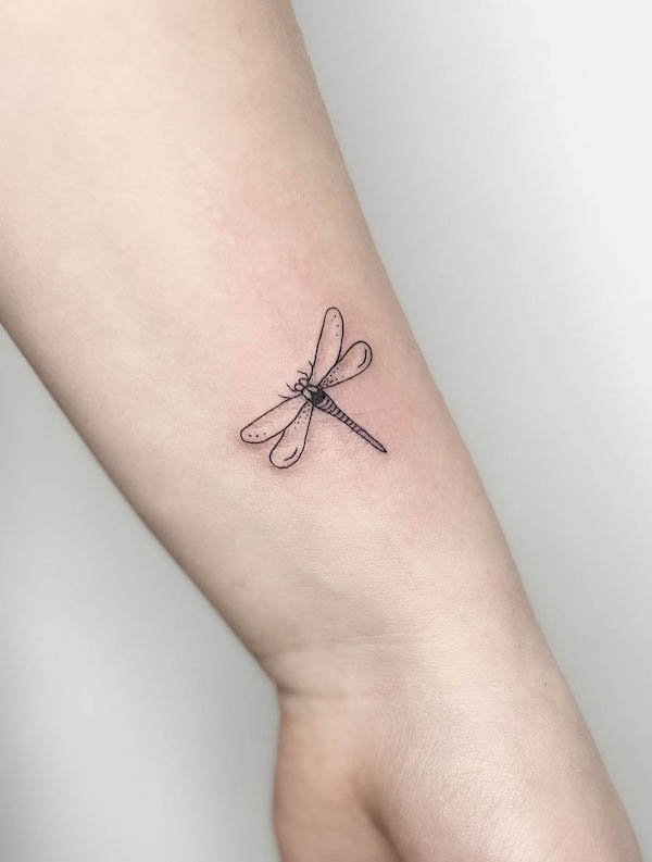 Tatuaggio da polso minimalista a forma di libellula di @frau.ines_