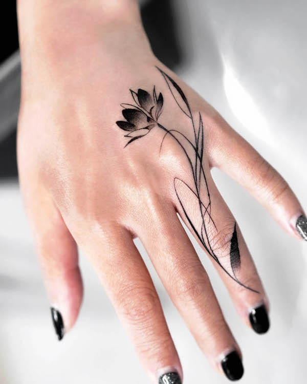 Tatuaggio della mano con fiore di loto di @mukyeon_tattoo