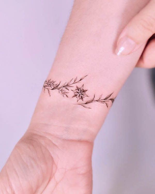 Tatuaggio con stella e braccialetto floreale di @tattooist_gaon