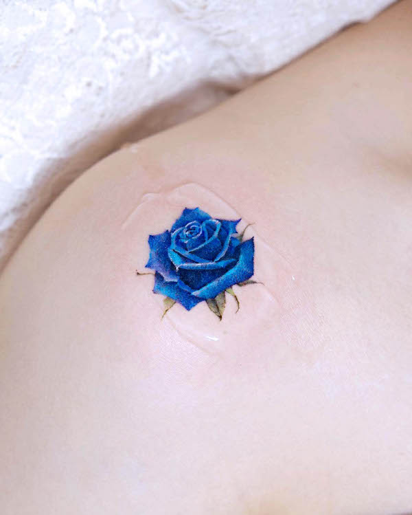 Splendido tatuaggio a spalla con rosa blu di @tilda_tattoo