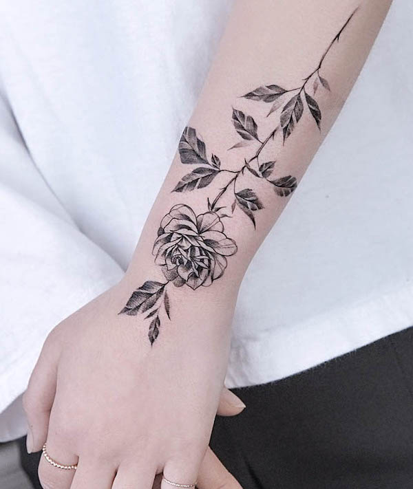 Tatuaggio di rosa sul polso e sulla mano di @tattooist_green