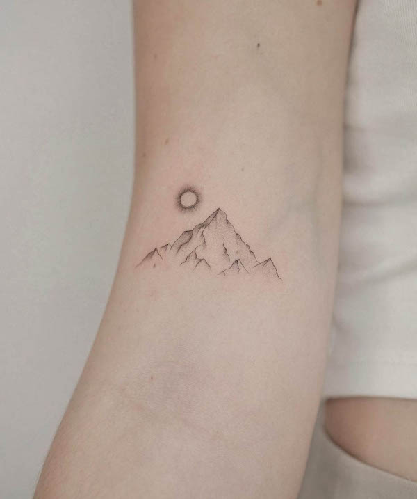 Il tatuaggio del sole nascente in montagna di @tatuatore_veronik