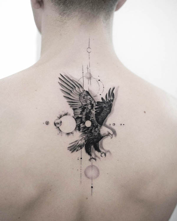 Tatuaggio posteriore con aquila e sole di @bartektattoo