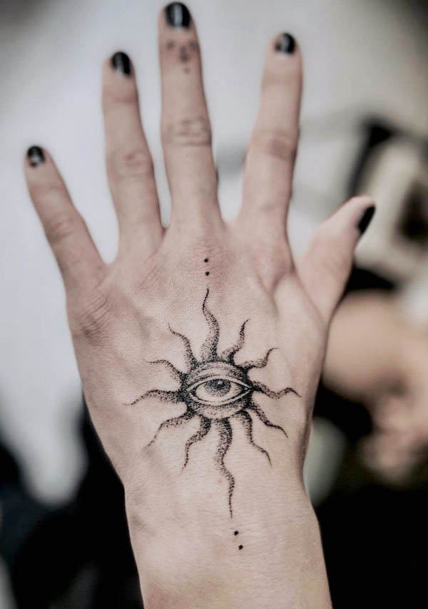 Tatuaggio a mano con occhio stregato e sole di @melpzvc