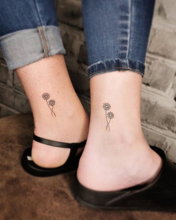Tatuaggi floreali madre-figlia sulla caviglia di @emilia_paw_arts