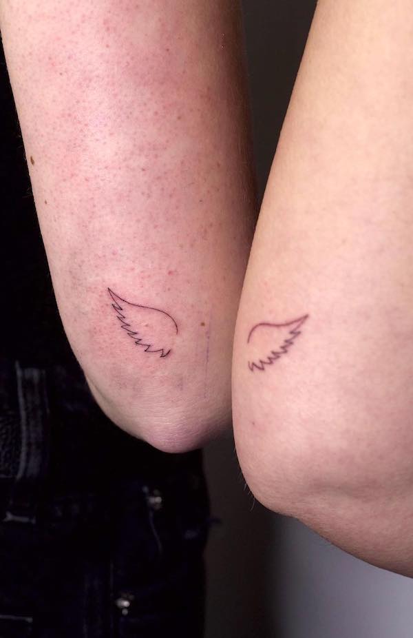 Tatuaggio al gomito con le ali da @alunar.ink