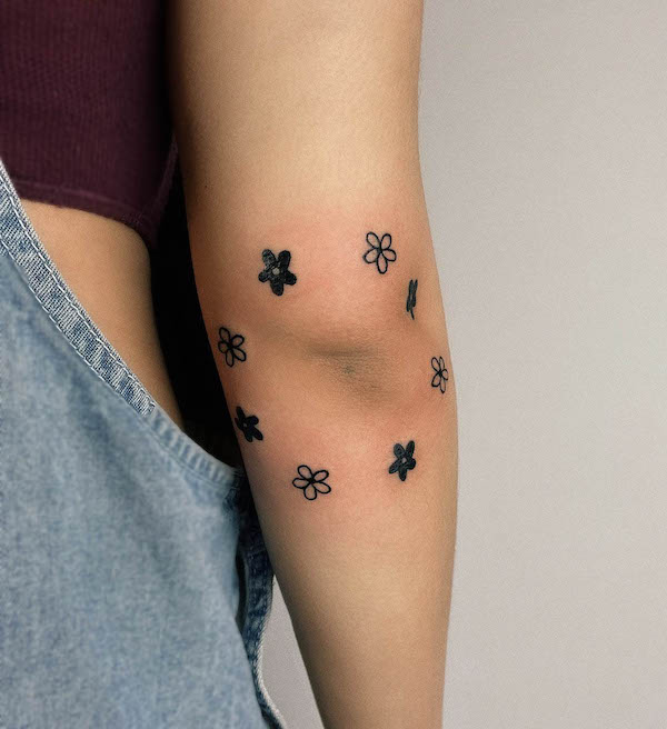 Tatuaggio a gomito con piccoli fiori di @bethkweedaytattoo