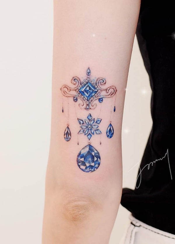 Tatuaggio di gioielli con pietre preziose sopra il gomito realizzato da @tattooist_jammy.j