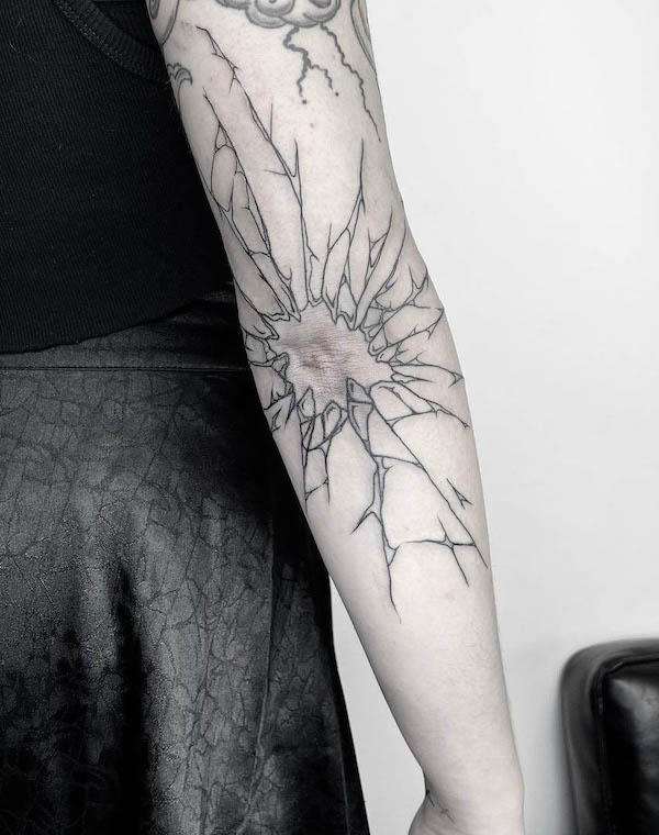 Tatuaggio a gomito con occhiali rotti di @crimclay