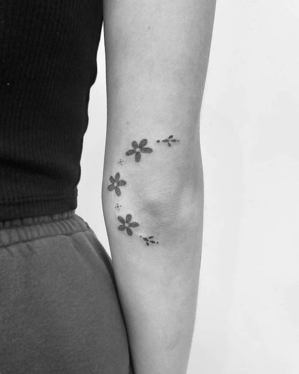 Piccolo fiore intorno al gomito da @kruczeu.tattoo