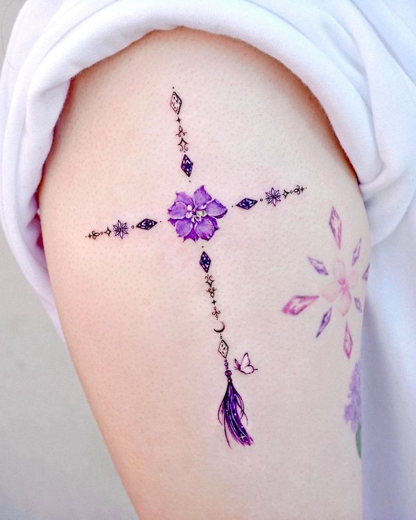 Tatuaggio con simbolo di crescita del delphinium di @tattooist_solar