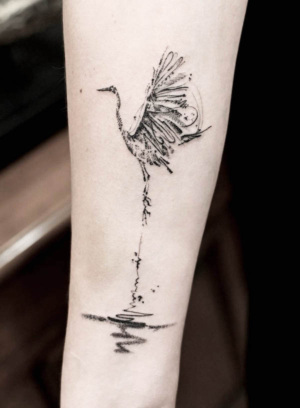 Gru in piedi sull'acqua tatuaggio di @joytattoo