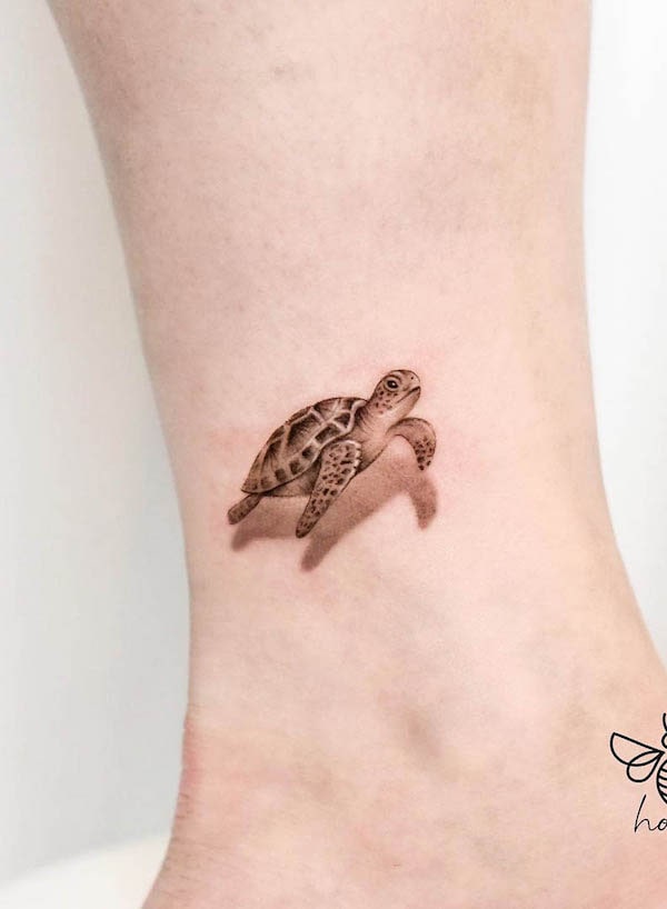 Tartaruga realistica nera e grigia tatuata da @_hony_tattoo