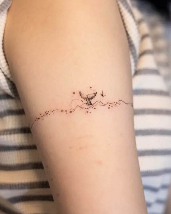 Tatuaggio a fascia con balena e onde di @handitrip
