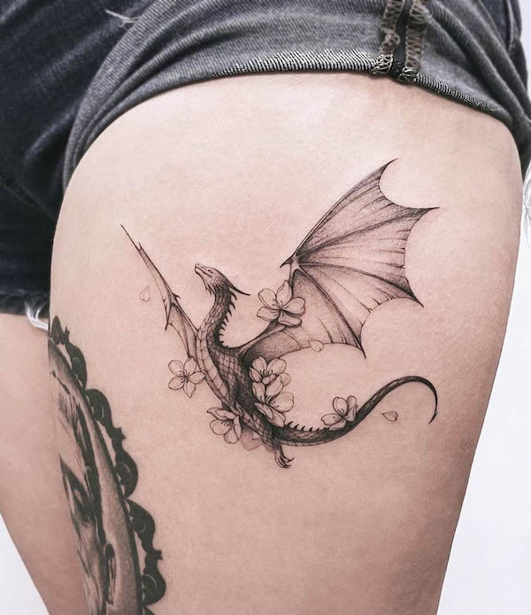 Tatuaggio floreale del drago sulla coscia da @baronarttattoo