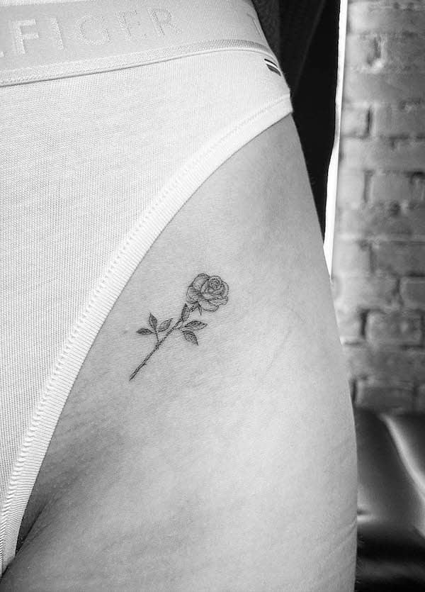 piccolo tatuaggio di rosa sulla coscia da @line.art_.tattoo