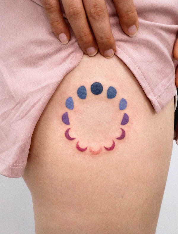 Tatuaggio sulla coscia con fasi lunari color arcobaleno di @tattooist_sigak