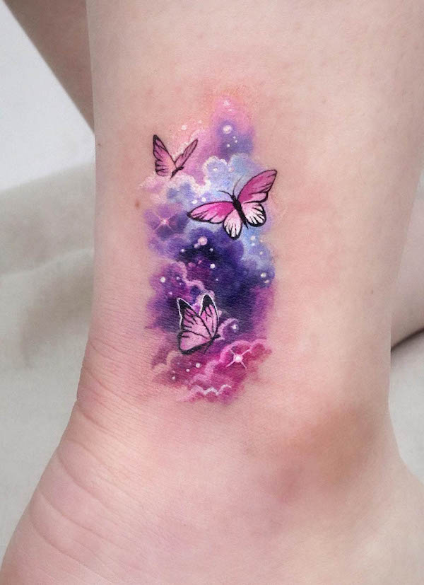 Tatuaggio con farfalla e galassia acquerellata di @tattooist_sigak