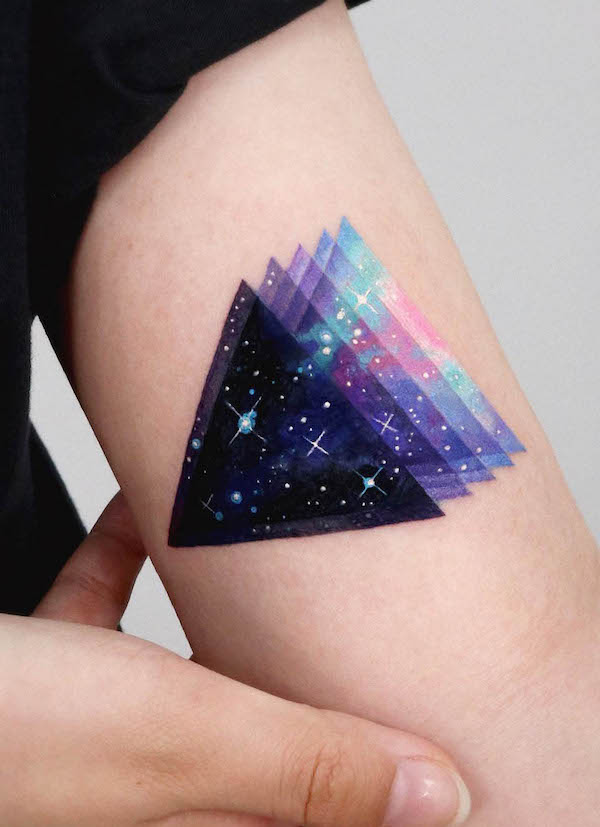 Tatuaggio acquerellato con galassia a triangolo di @tattooist_sigak