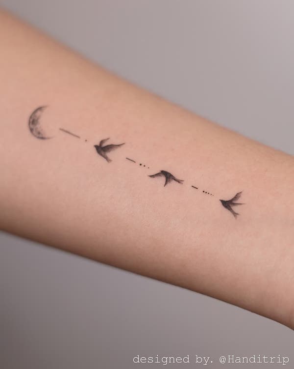 Tatuaggio minimalista con uccello volante nero e grigio di @handitrip