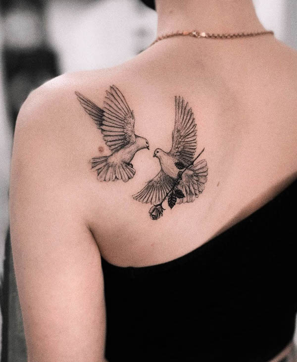 Una coppia di colombe sulla schiena di @vic.ink_