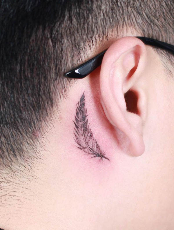 Tatuaggio con piume dietro l'orecchio di @inkhome