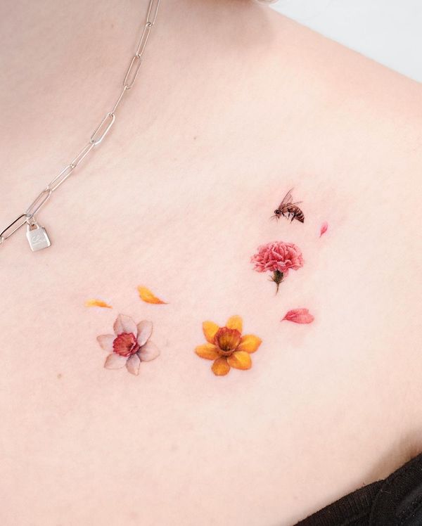 Tatuaggio di piccoli fiori e api sulla clavicola da @donghwa_tattoo