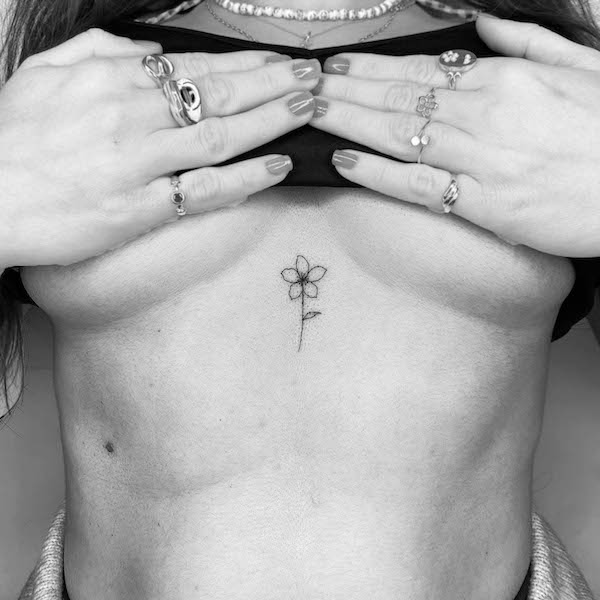Tatuaggio dello sterno a fiore piccolo di @cagridurmaz