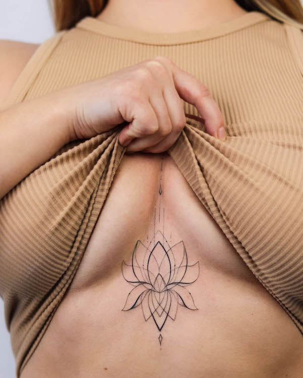 Tatuaggio con contorno di loto tra i seni di @dasha_sumtattoo
