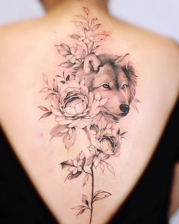 Tatuaggio floreale con spina dorsale di lupo di @baronarttattoo
