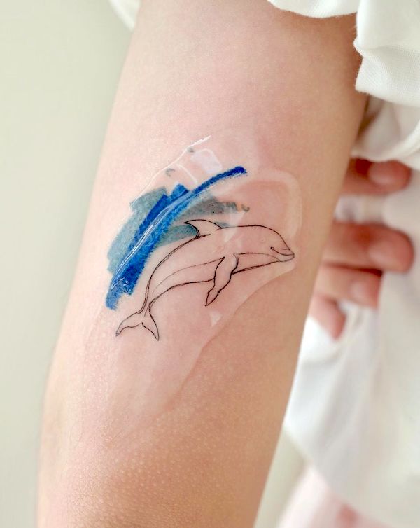 Tatuaggio minimalista di delfino di @tattoo_joojoo