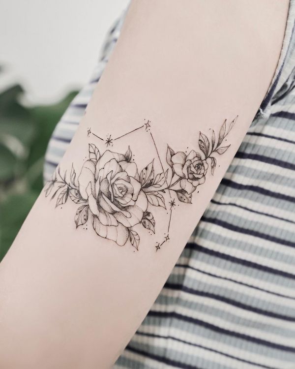 Intricato tatuaggio di rose e costellazioni di @eat_my_pen