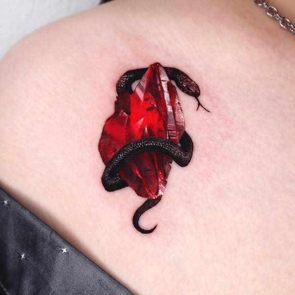 Tatuaggio con cobra nero e pietre preziose di @tattooist_coldy