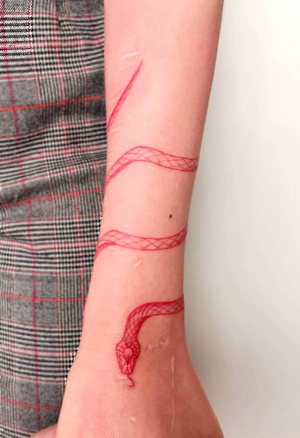 Tatuaggio a forma di serpente rosso intorno al braccio by @frannk.tattoo