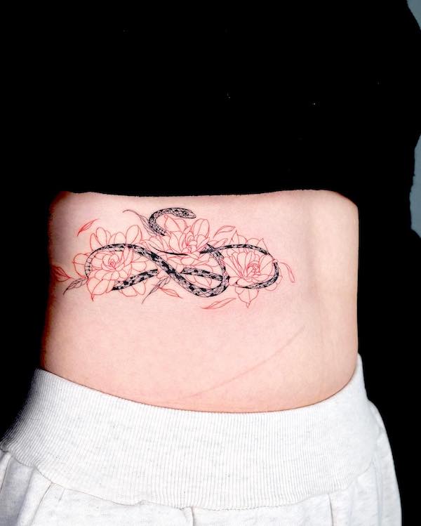 Tatuaggio con serpente e fiori di @bium_tattoo