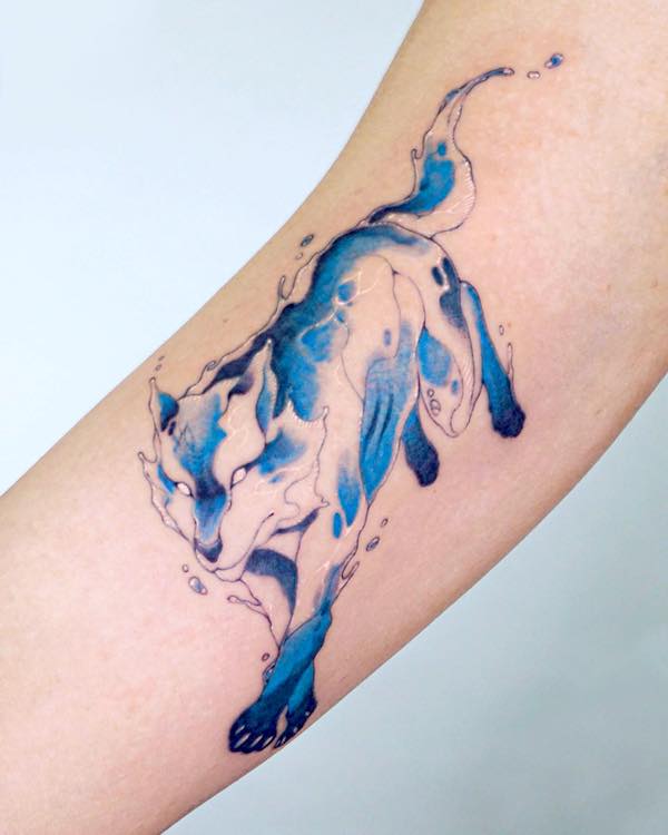 Tatuaggio bicipite lupo blu di @tattooist.inno