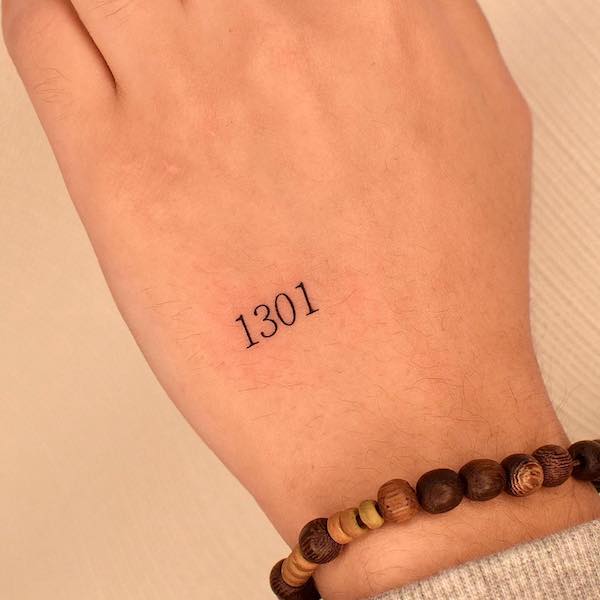 Tatuaggio della mano con numero piccolo di @tatuatore_jina