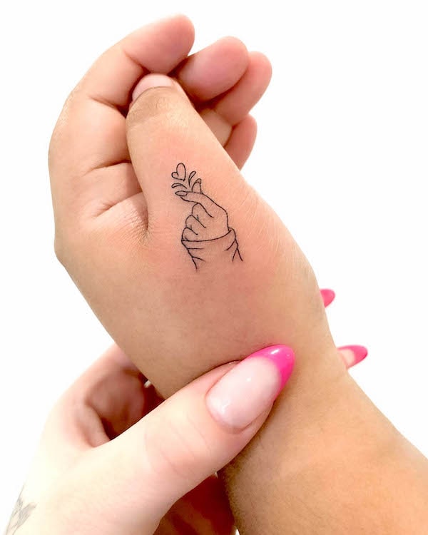 Tatuaggio a mano con il dito a forma di cuore da @joannamroman