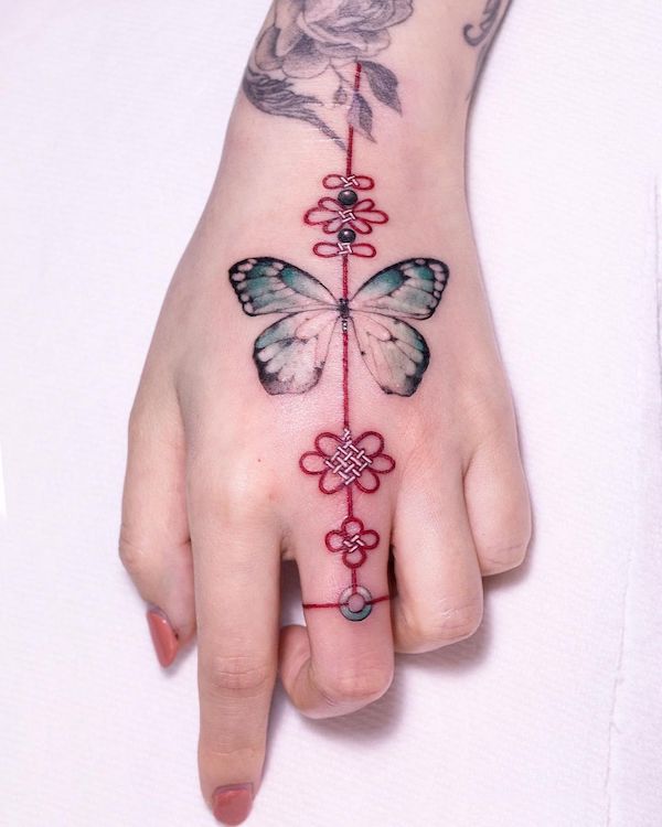 Tatuaggio a mano con farfalla e nodo di @tattooist_sion