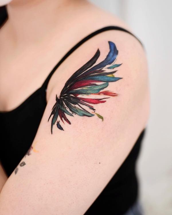 Tatuaggio con ali sulla parte superiore del braccio di @9room_tattoo