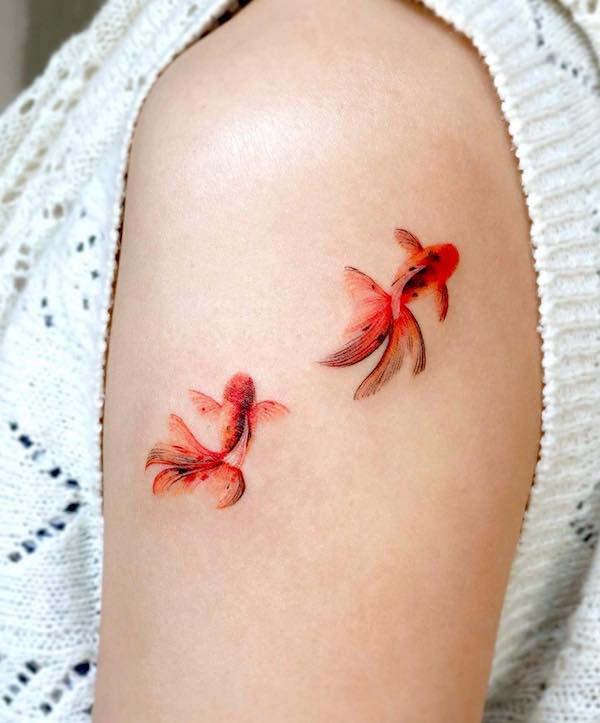 Tatuaggio del pesce rosso sulla parte superiore del braccio di @eunyutattoo