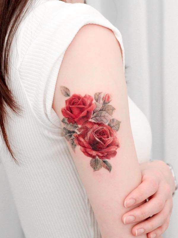 Tatuaggio con rosa acquerellata sulla parte superiore del braccio di @vandal_tattoo