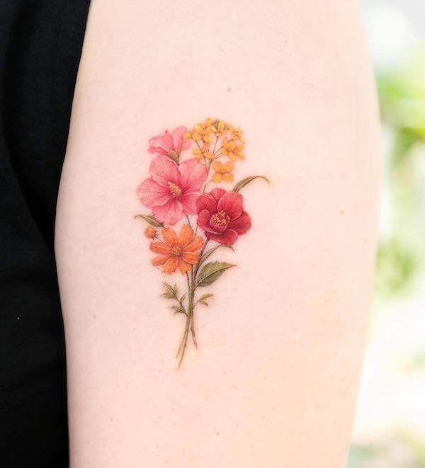 Bellissimo bouquet tatuato sulla parte superiore del braccio da @palette.tt
