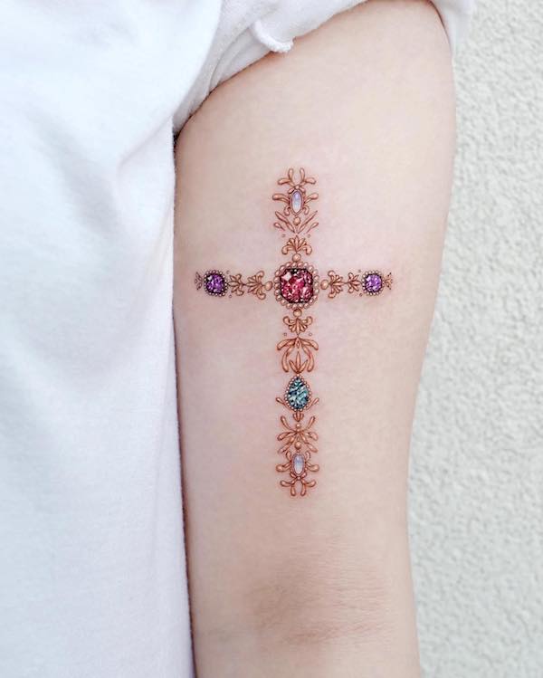 Tatuaggio del braccio con croce di pietra preziosa di @tattooist_solar