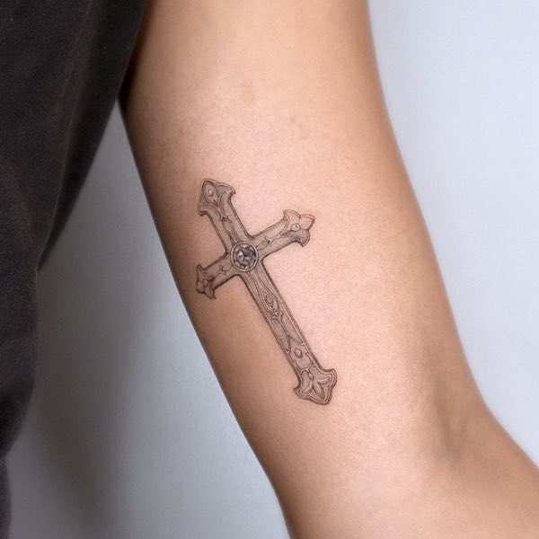 Tatuaggio vintage con croce sul bicipite di @choseung.tat