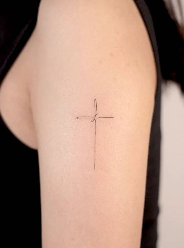 Tatuaggio semplice con croce sul braccio esterno di @handitrip