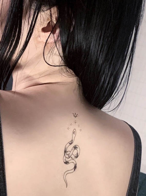 Tatuaggio con serpente nero sulla schiena di @e.hyang_ tattoo