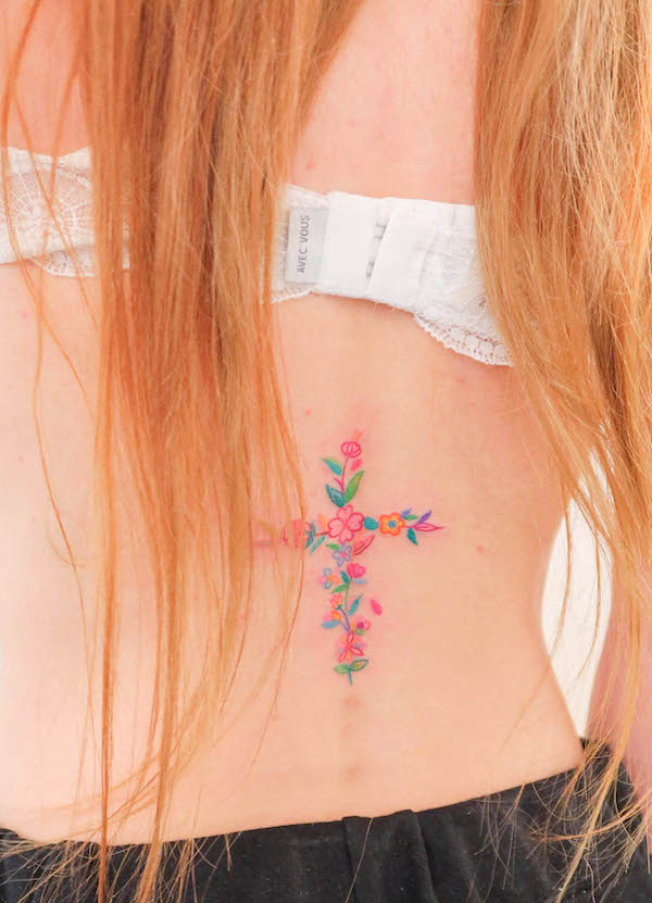 Tatuaggio girly con croce floreale sulla parte bassa della schiena di @sisi.lovelove
