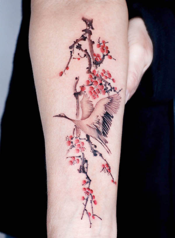 Tatuaggio con fiori di ciliegio e gru di @yeobaeg_tattoo