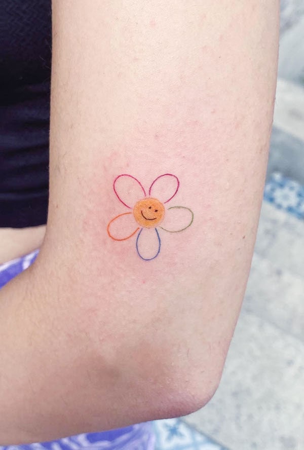 Tatuaggio del gomito con fiori arcobaleno di @berivanis.tatts